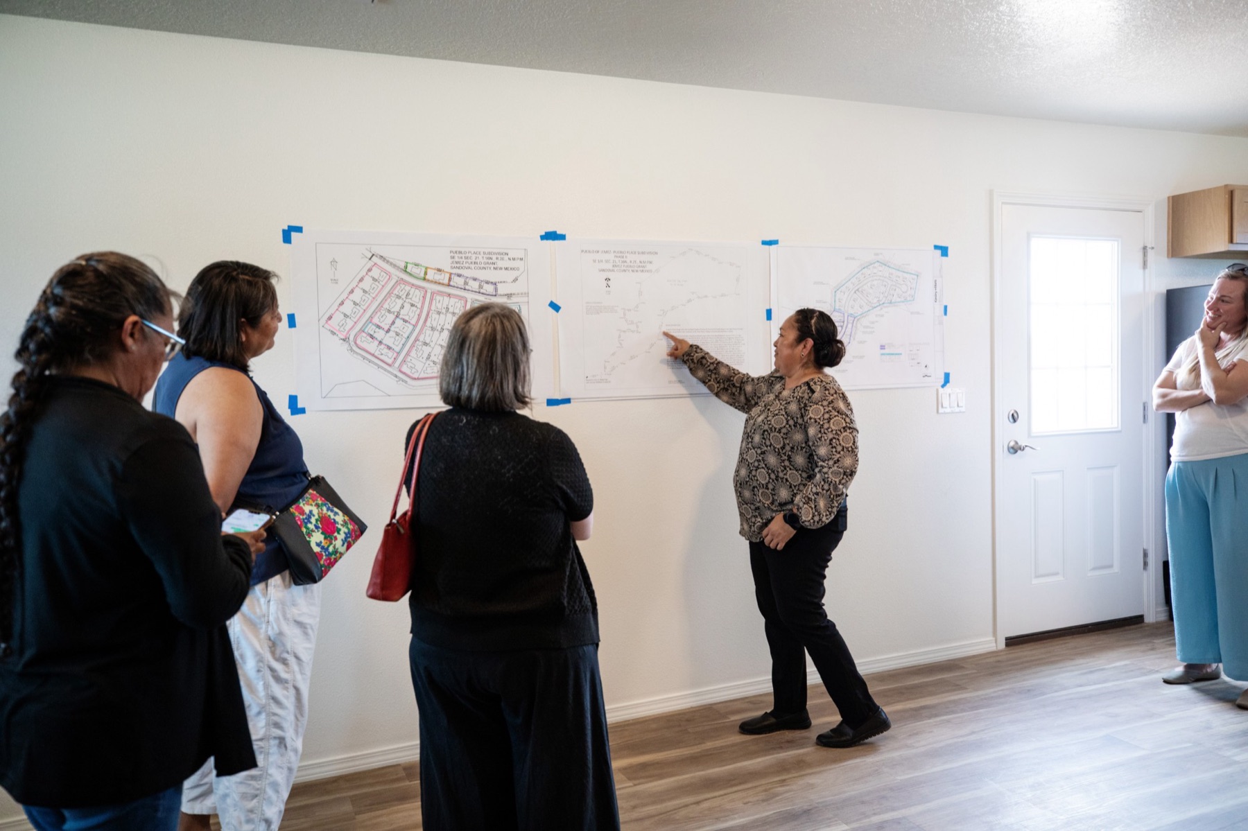 A housing staff member walks visitors through subdivision plans inside a new home at the Pueblo of Jemez